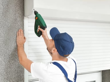 Volets roulants fermés sur une fenêtre pour réduire les déperditions thermiques d'une maison
